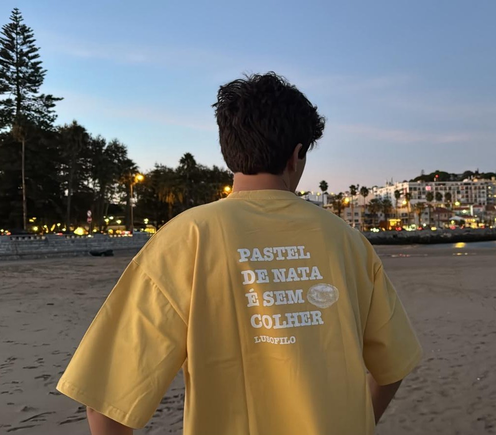 Pessoa de costas com t-shirt branca LusoFilo com a frase Pastel de nata é sem colher